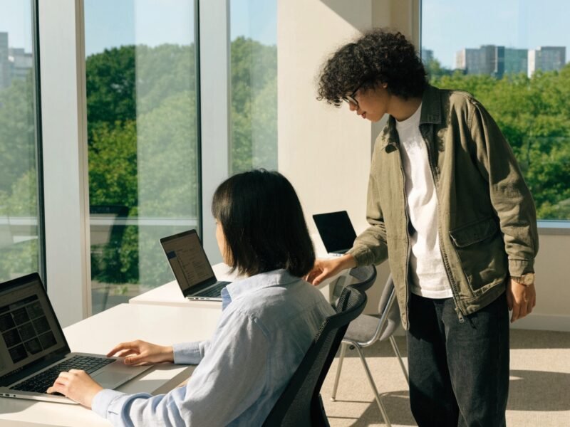 Equipe de agência de marketing digital analisando estratégias integradas em gráficos e telas
