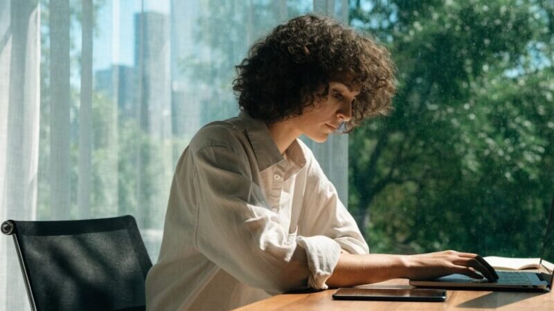 Equipe de agencia de sites trabalhando em computadores com prototipos de paginas na tela